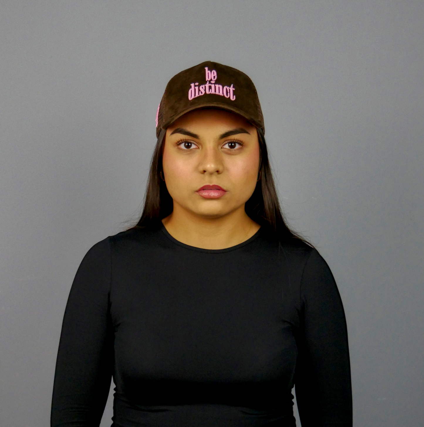 KELIX Velours Cap in Braun mit pinkem 'be distinct' Stick โ Seitenansicht und Frontansicht einer Person, die die Kappe trรคgt.