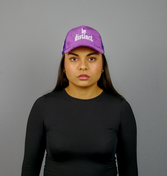 KELIX Velours Cap in Lila mit weißem 'be distinct' Stick – Frontansicht einer Person, die die Kappe trägt, zusammen mit einer Seitenansicht der Kappe und einer weiteren Person im schwarzen Hoodie mit lila Kappe.